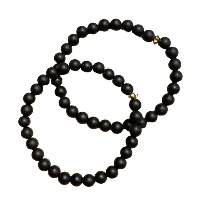 Armbånd med sorte perler og guldblomst - Friihof + Siig